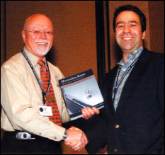 MBCA National President Richard Simonds (left) accepts a copy of the <b>Mercedes-Benz Technical Companion</b> at Startech 2005 from Bentley Publishers Editor Josh Davidson